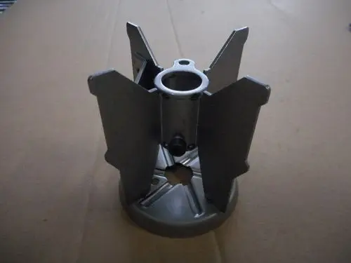 Remeha Turbulator, metallisches Teil mit fünf verstellbaren Lamellen, zentraler Öffnung und runder Basis, auf braunem Kartonhintergrund abgebildet.